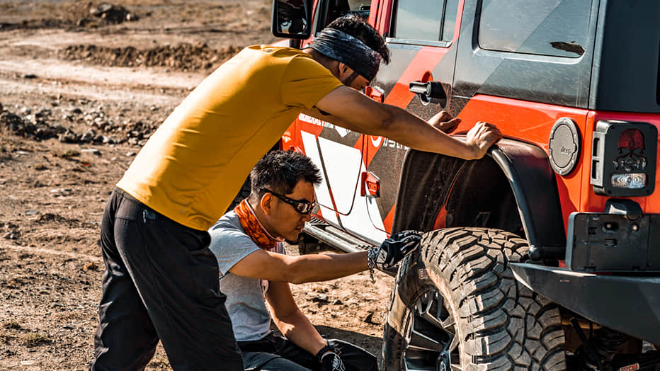 穿越北疆茫茫戈壁，需要精确掌握轮胎胎压。小齐和宏义正在给轮胎放气，这样在沙漠戈壁行驶时，才会有更好的附着力。