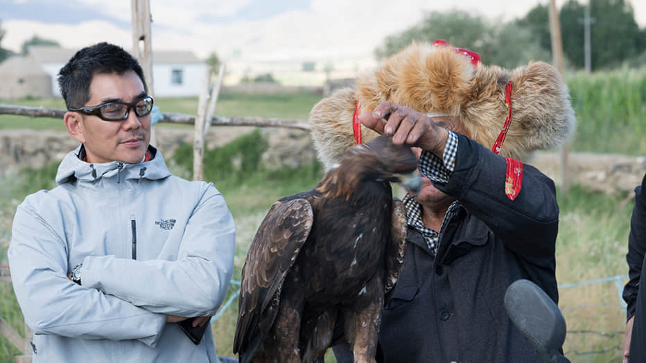 哈萨克老人与小齐聊起鹰猎的传统。说到如今年轻人都在外地工作，村里很多鹰猎人都去世了，延续这项传统越来越难，言语中有些哽咽。